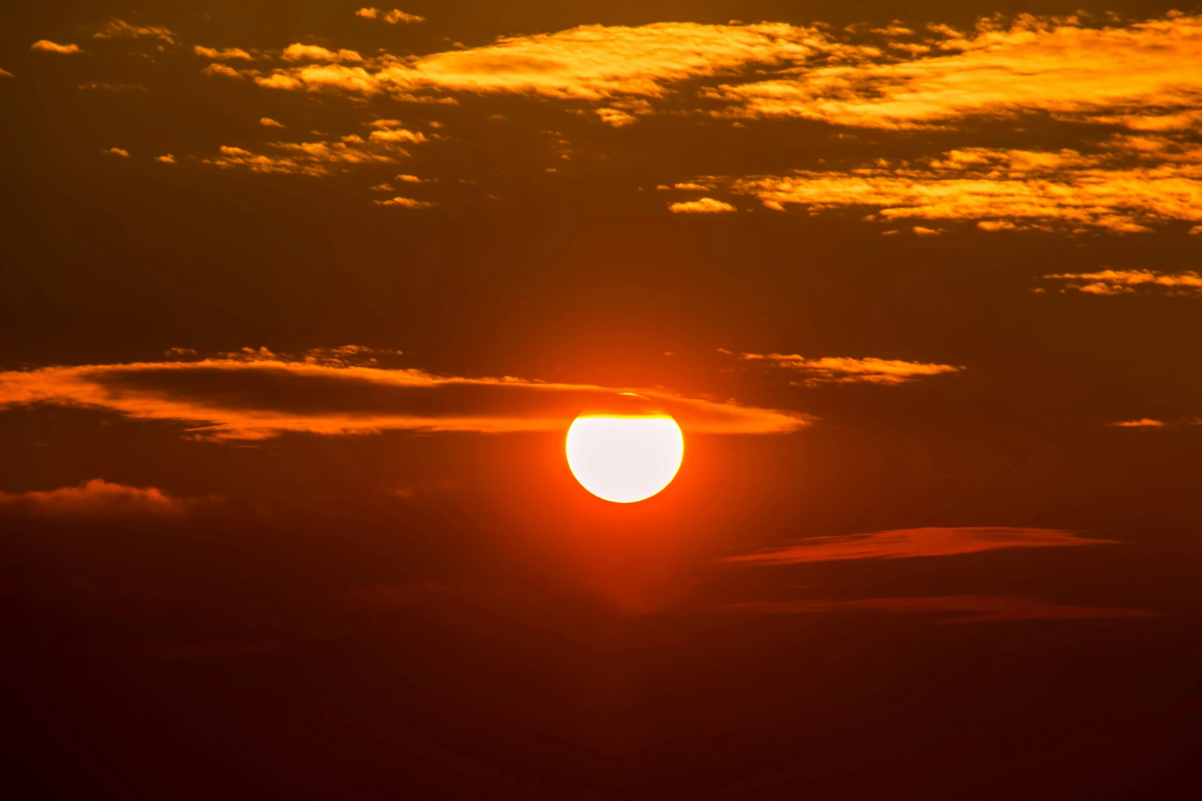 the sun is setting behind the clouds in the sky, by Matthew Smith, pexels, digital yellow red sun, hot and humid, wide, may 1 0