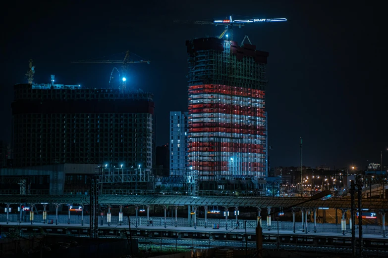 a very tall building with a crane on top of it, by Sebastian Spreng, unsplash contest winner, constructivism, blue and red lights, russia in 2 0 2 1, under construction, during night