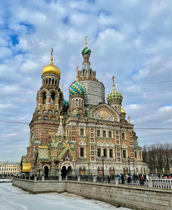 a large church sitting on top of a snow covered field, inspired by Vasily Surikov, pexels contest winner, baroque, brown and cyan color scheme, building along a river, square, dome