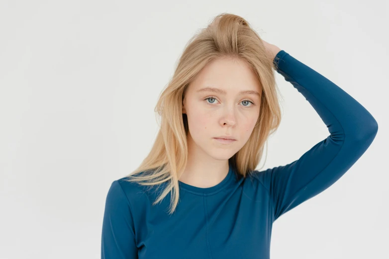 a woman in a blue shirt posing for a picture, silicone skin, pale ivory skin, bowater charlie, full product shot