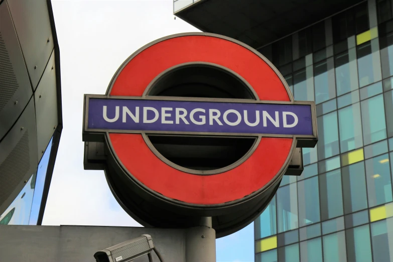 a close up of a sign with a building in the background, by Rupert Shephard, unsplash, underground comix, tube wave, 🚿🗝📝