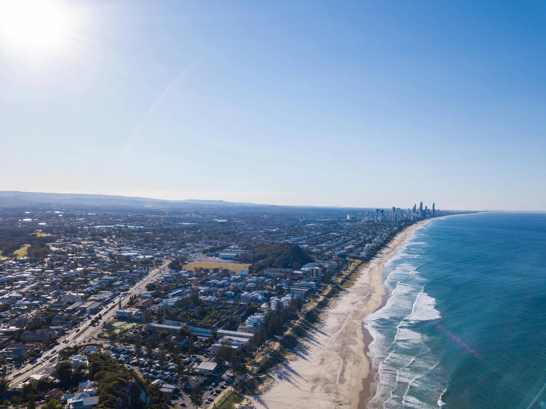 an aerial view of a beach and the ocean, by Lee Loughridge, unsplash contest winner, happening, super wide view of a cityscape, clear blue skies, lachlan bailey, 15081959 21121991 01012000 4k