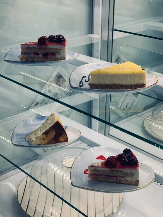 a display case filled with lots of different types of cakes, a photo, inspired by Wolfgang Letti, unsplash, hyperrealism, 3 - piece, indoor, 🐿🍸🍋