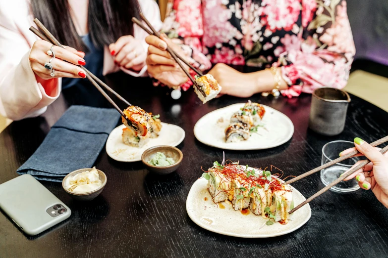 a group of people eating sushi and chopsticks, unsplash, mingei, melbourne, obi strip, 40 years old women, 💣 💥