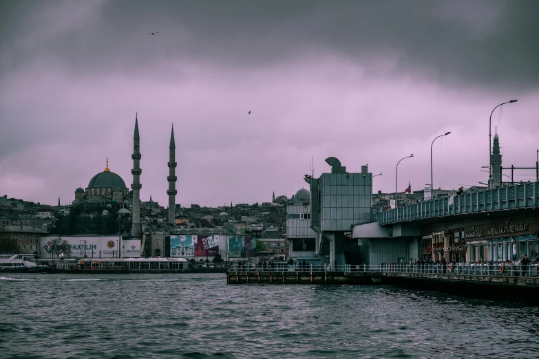 a large body of water next to a bridge, a colorized photo, by Ismail Acar, pexels contest winner, hurufiyya, grey skies rain, minarets, harbour in background, vaporwave city