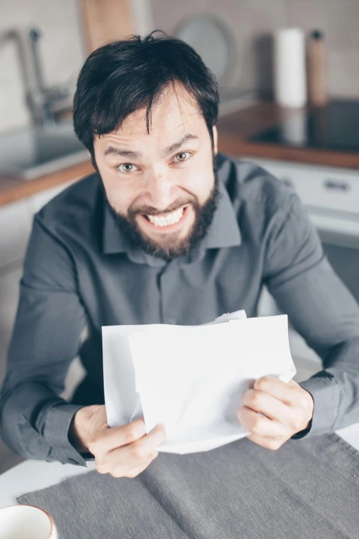 a man sitting at a table holding a piece of paper, all overly excited, beard stubble, selling insurance, letters