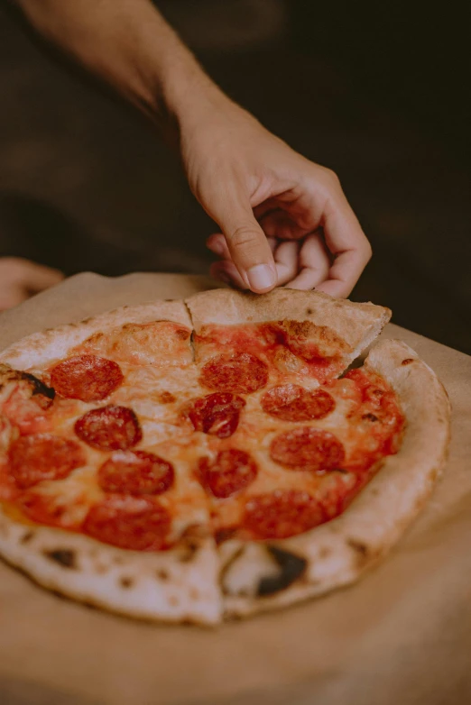 a person cutting a pepperoni pizza on a cutting board, pexels contest winner, renaissance, parchment paper, (night), iconic scene, petite