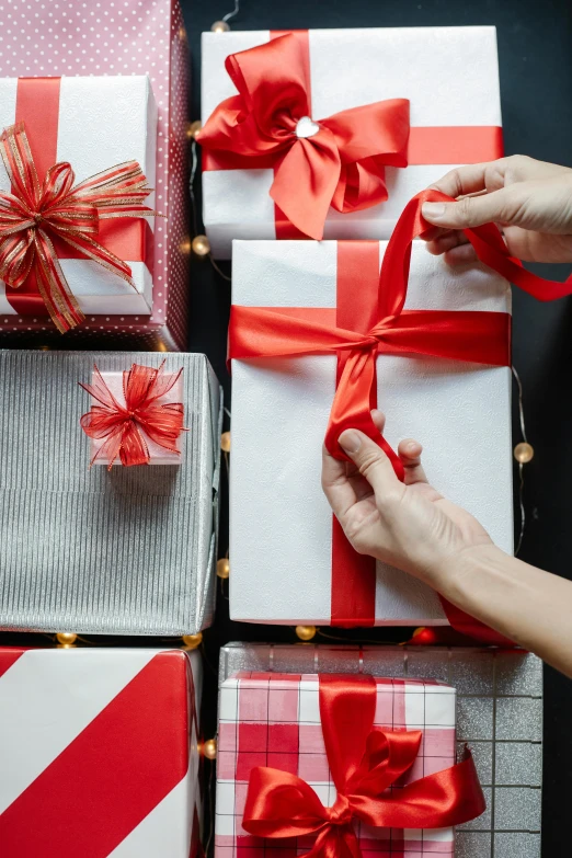 a person putting a red ribbon on a stack of gift boxes, curated collections, thumbnail, petite, square