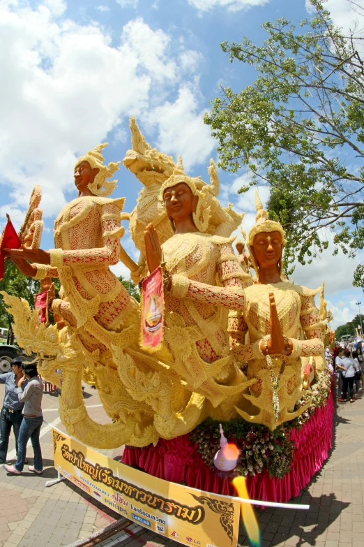 a group of people riding on top of a float, a statue, in style of thawan duchanee, butter sculpture, in a row, immaculately detailed