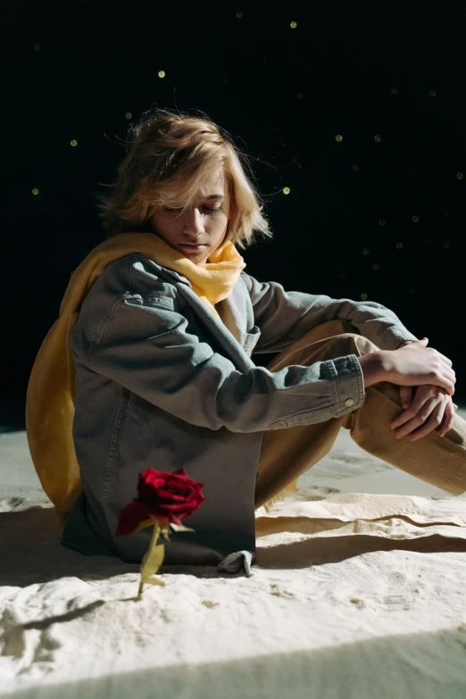a woman sitting on top of a snow covered ground, an album cover, by Leila Faithfull, romanticism, johan liebert, wearing a hoodie and flowers, in a gold suit, lonely astronaut