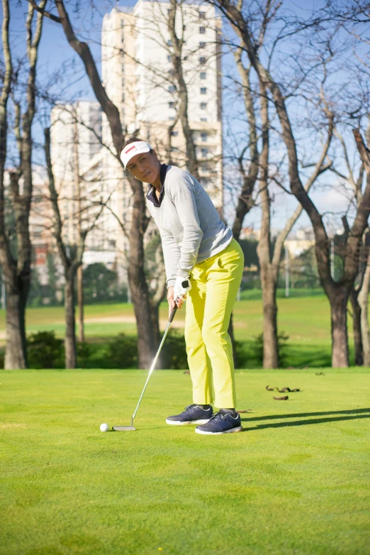 a woman in yellow pants playing a game of golf, inspired by Luis Molinari, instagram, happening, madrid, profile image, performance, one green