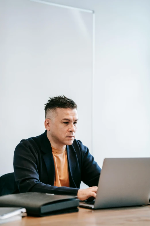a man sitting at a table working on a laptop, pexels contest winner, looking serious, lgbtq, official screenshot, jeremy lipkin