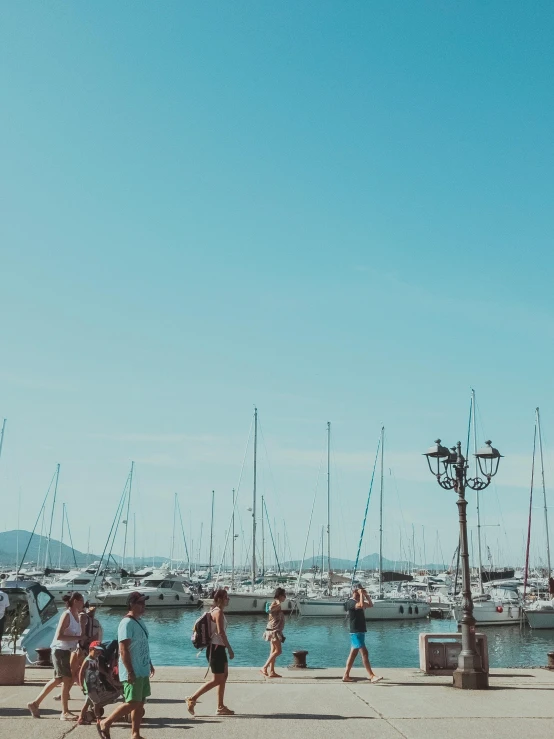 a group of people walking down a sidewalk next to a marina, a picture, pexels contest winner, ibiza, thumbnail, high quality image, cinematic lut