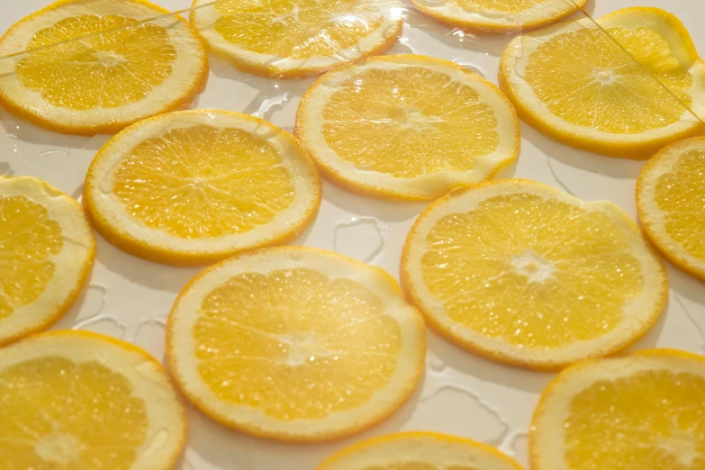 a white plate topped with sliced oranges on top of a table, process art, liquid translucent amber, with lemon skin texture, infused, round-cropped