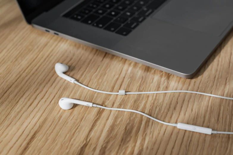 a laptop computer sitting on top of a wooden table, an album cover, by Matthias Stom, unsplash, earbuds jewelry, satisfying cable management, white, modeled