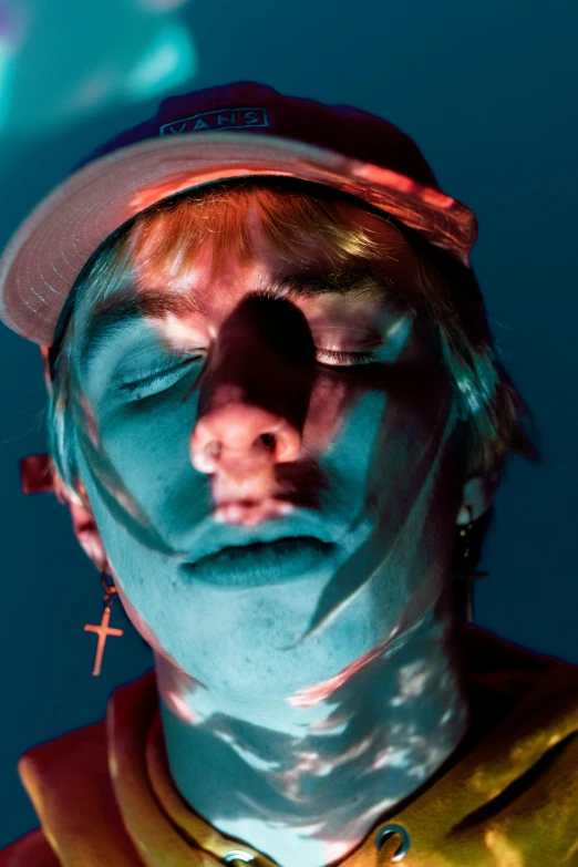 a close up of a person with a clown nose, an album cover, inspired by Elsa Bleda, trending on pexels, hyperrealism, wearing teal beanie, holes in a religious man, looks like a mix of grimes, high red lights