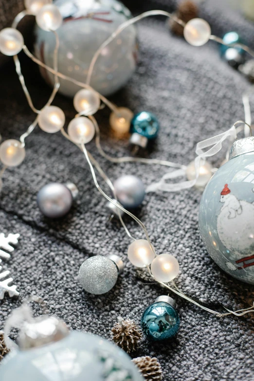 a bunch of ornaments sitting on top of a table, by Helen Stevenson, unsplash, grey and blue theme, string lights, flat lay, multiple stories