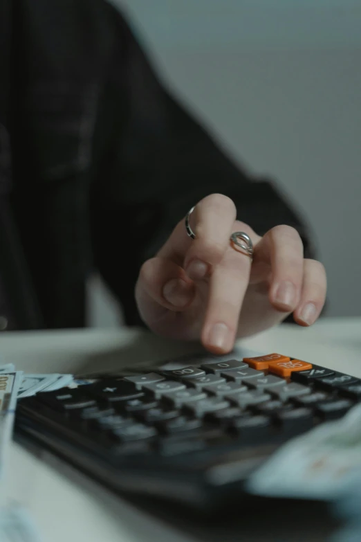 a close up of a person using a calculator, inspired by Elsa Bleda, trending on reddit, 2 0 2 1 cinematic 4 k framegrab, golden ratio jewelry candy, ignant, hand on table