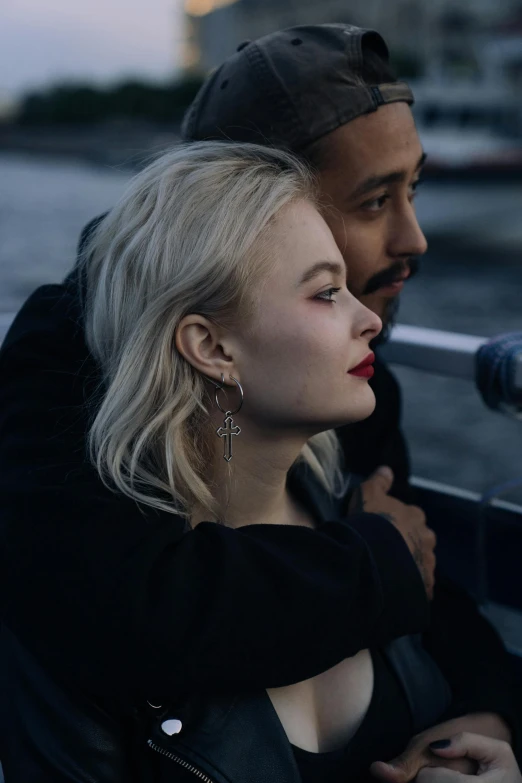 a woman sitting next to a man on a boat, a photo, inspired by Louisa Matthíasdóttir, trending on pexels, realism, prominent jawline, official music video, blonde, enes dirig