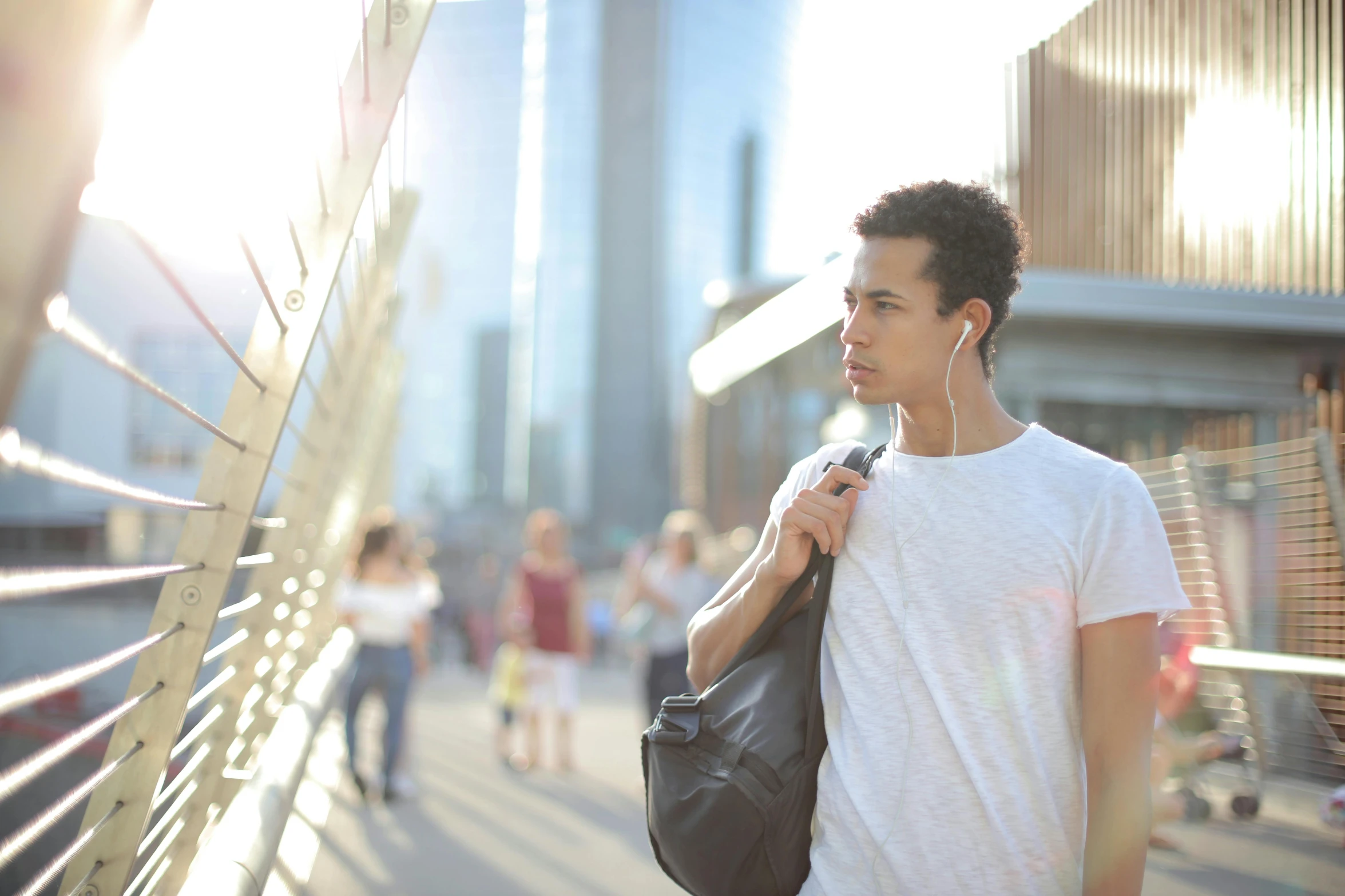 a man in a white shirt carrying a black bag, pexels, earbuds, in a modern city, avatar image, australian