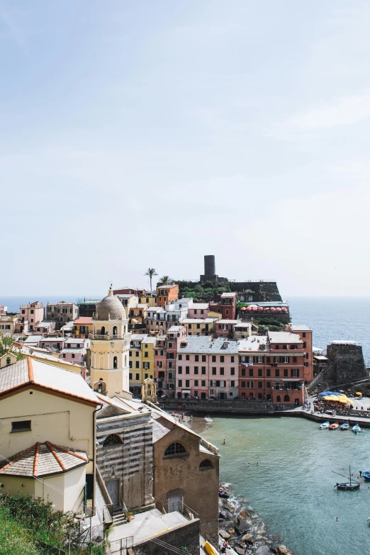 a group of boats floating on top of a body of water, by Patrick Pietropoli, pexels contest winner, mediterranean architecture, overlooking the ocean, slide show, chimneys on buildings