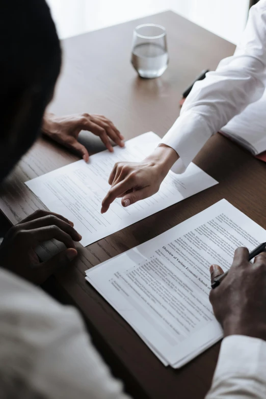 a couple of people that are sitting at a table, pexels contest winner, renaissance, signing a bill, black on white, dark people discussing, selling insurance