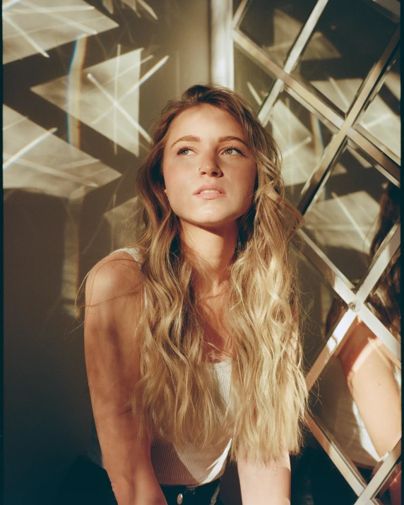 a beautiful young woman sitting in front of a window, an album cover, by Sara Saftleven, trending on pexels, amber heard, glowing with silver light, beautiful taissa farmiga, tanned