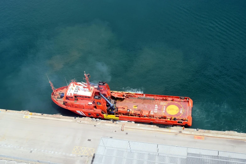 a large red boat sitting on top of a body of water, a picture, helipad, high angle shot, redundancy, set on fire