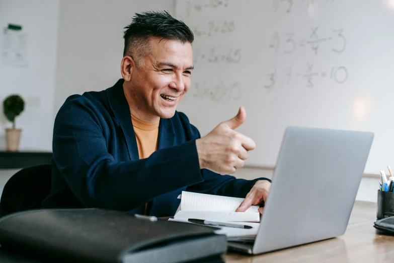 a man sitting in front of a laptop giving a thumbs up, pexels contest winner, teacher, ross tan, profile image, middle aged man