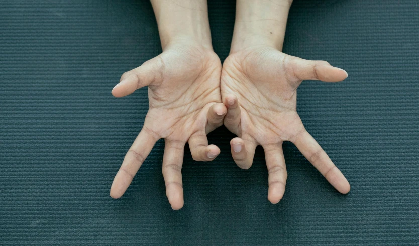 a close up of a person's hands on a yoga mat, by Anna Findlay, unsplash, hyperrealism, marfan syndrome, shrugging, cysts, geometrically realistic