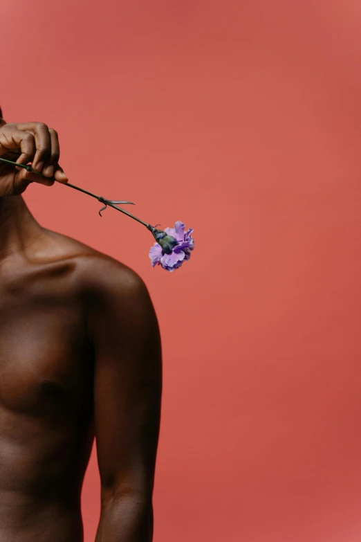 a shirtless man holding a flower in his mouth, an album cover, unsplash, afroamerican, photographed for reuters, lgbtq, ignant