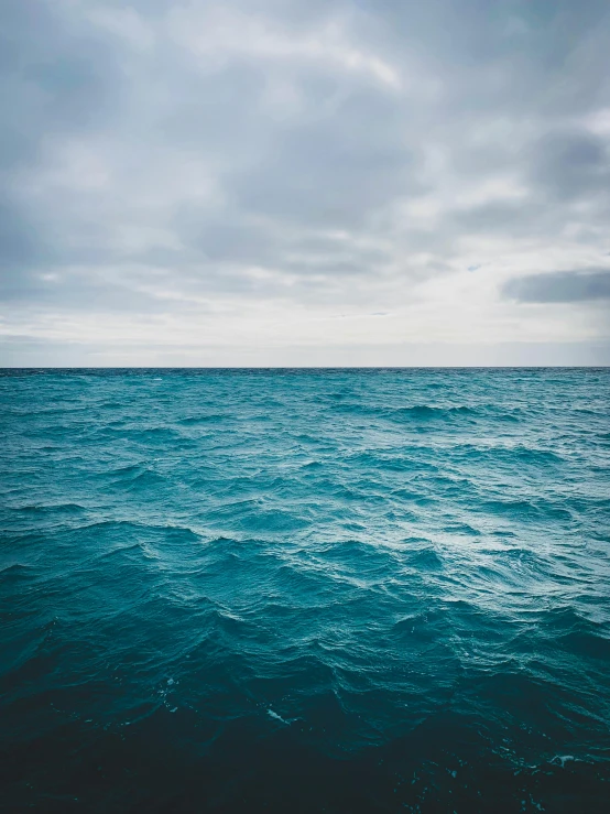 a large body of water under a cloudy sky, at the bottom of the ocean