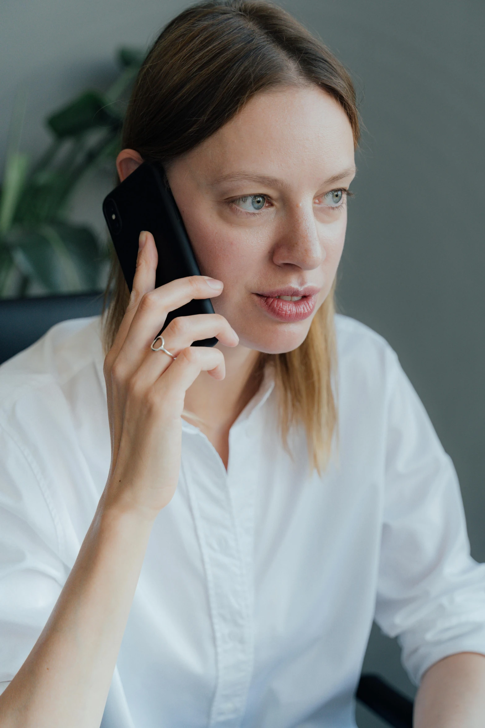 a woman sitting at a desk talking on a cell phone, pexels contest winner, renaissance, wearing white v - neck top, kirsi salonen, corporate phone app icon, office clothes