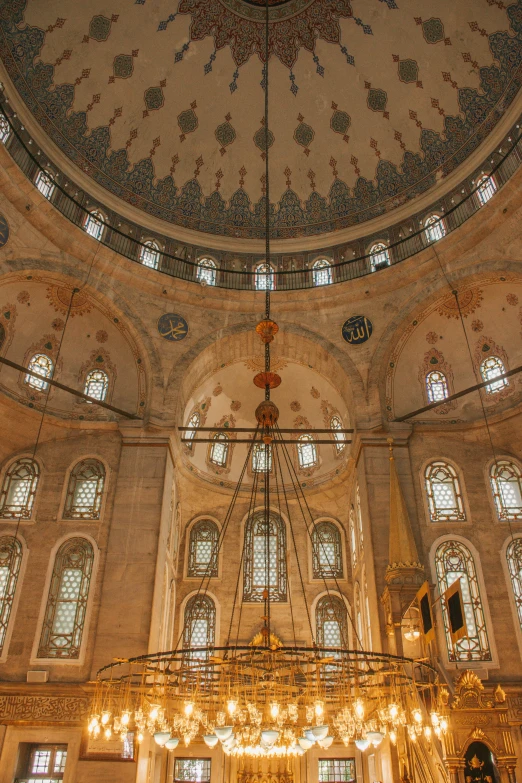 a large chandelier hanging from the ceiling of a building, inspired by Osman Hamdi Bey, arabesque, black domes and spires, church interior, grey, ox