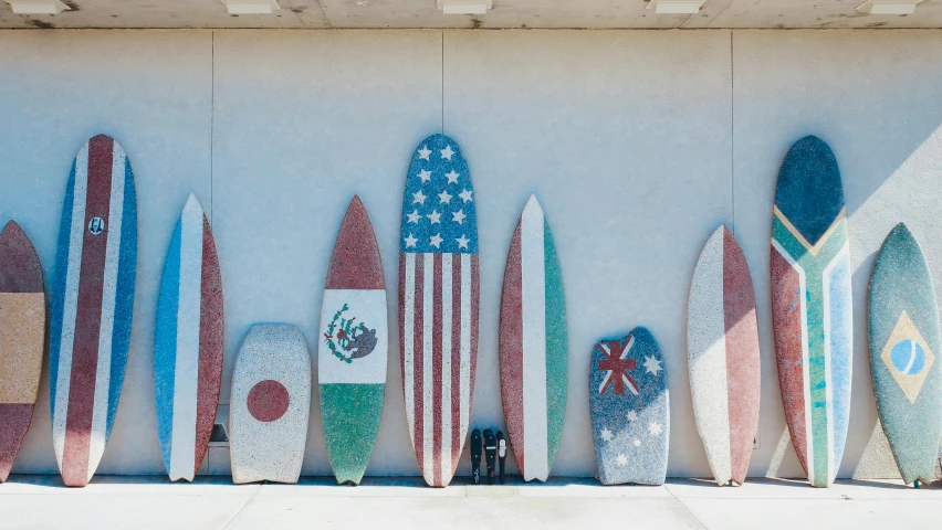 a row of surfboards lined up against a wall, a mosaic, unsplash contest winner, concrete art, american flags, profile image, not japanese, conde nast traveler photo