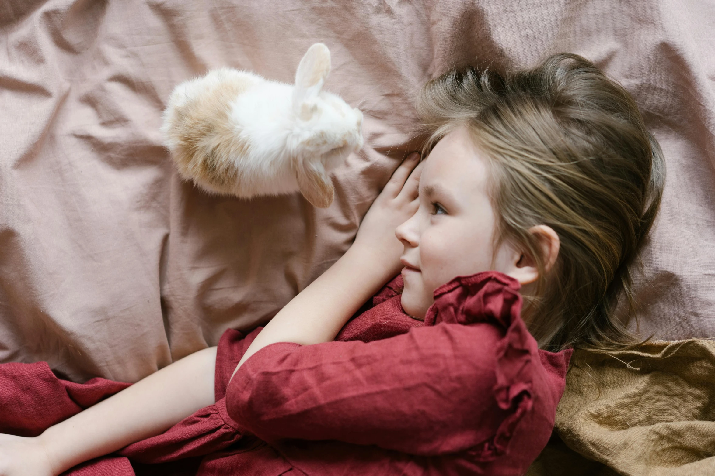 a little girl laying on top of a bed next to a cat, pexels contest winner, renaissance, rabbit ears, very very small goat, greta thunberg, rabbit_bunny