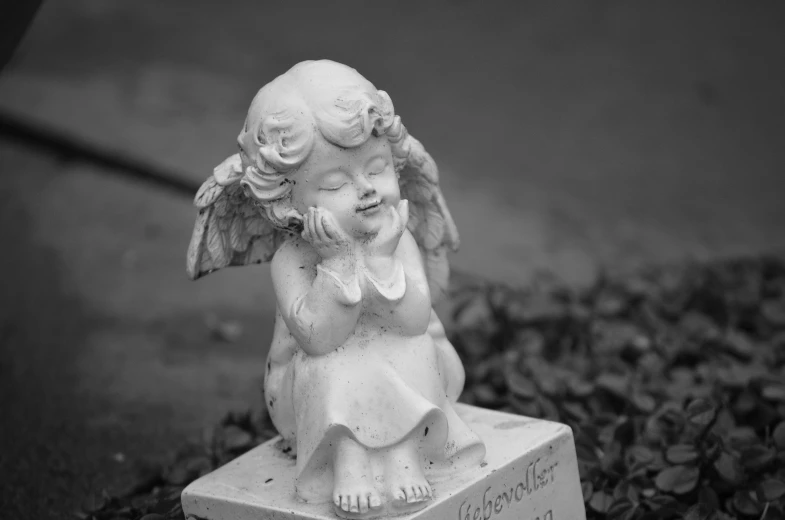 a black and white photo of a statue of an angel, a statue, cute decapodiformes, sad and happy, tombstone, small fairies
