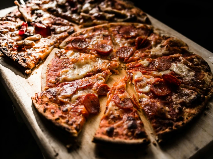 a pizza sitting on top of a wooden cutting board, by Niko Henrichon, pexels, 6 pack, various posed, cheese and pepperoni, thumbnail