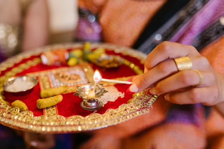 a close up of a person holding a plate with food on it, hurufiyya, wedding, holding a torch, hindu ornaments, profile image