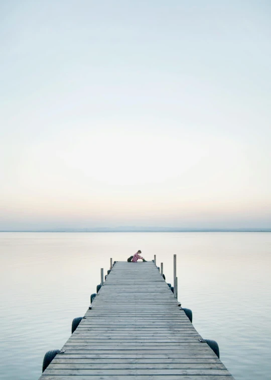 a pier in the middle of a body of water, by Holger Roed, man sitting facing away, kailee mandel, fine art print, dwell