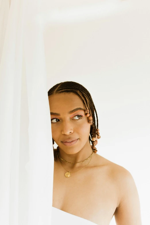 a woman standing in front of a white curtain, by Dulah Marie Evans, trending on pexels, antipodeans, cornrows, ashteroth, portrait sophie mudd, hair jewellery