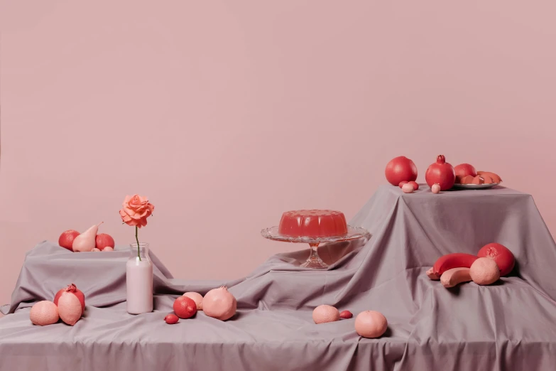 a cake sitting on top of a table covered in cloth, a still life, inspired by Anna Füssli, trending on unsplash, magic realism, pink and red color scheme, floating spheres and shapes, dead fruits, ignant