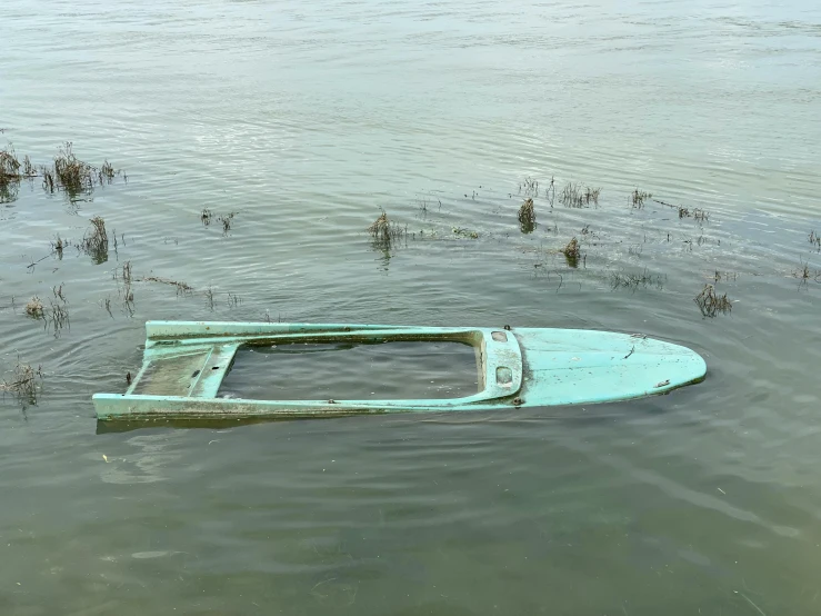 a boat sitting in the middle of a body of water, by Carey Morris, old abandoned car sinking, seafoam green, 2022 photograph, american realist