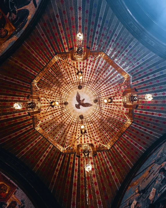 a chandelier hanging from the ceiling of a church, a mosaic, by Julia Pishtar, unsplash contest winner, an eagle, soft lighting from above, nepal, in the center of the image