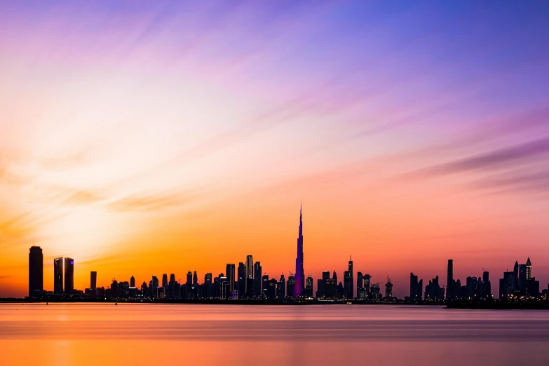 a large body of water with a city in the background, by Julia Pishtar, pexels contest winner, hurufiyya, dubai, vibrant sunset, album cover, youtube thumbnail