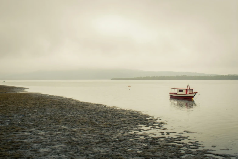 a boat sitting on top of a body of water, by Alison Geissler, under a gray foggy sky, crimson tide, skye meaker, landscape photo-imagery