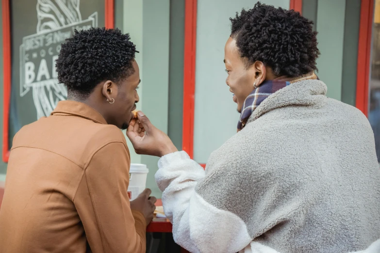 two people sitting at a table eating food, trending on pexels, visual art, east african man with curly hair, people waiting in bus stop, lesbians, profile image