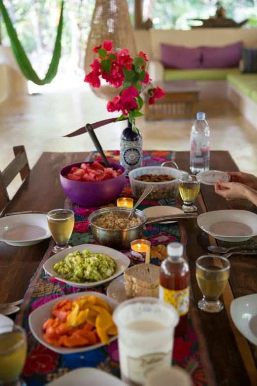 a woman sitting at a table with plates of food, happening, mexico, sol retreat, fruit bowl, square