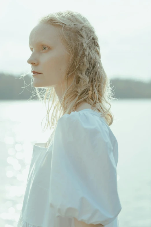 a woman standing in front of a body of water, an album cover, by Anna Boch, unsplash, renaissance, beautiful pale makeup, cream colored peasant shirt, elle fanning), soft portrait shot 8 k