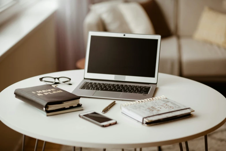 a laptop computer sitting on top of a white table, by Carey Morris, trending on pexels, multiple desks, with one vintage book on a table, brown, overview